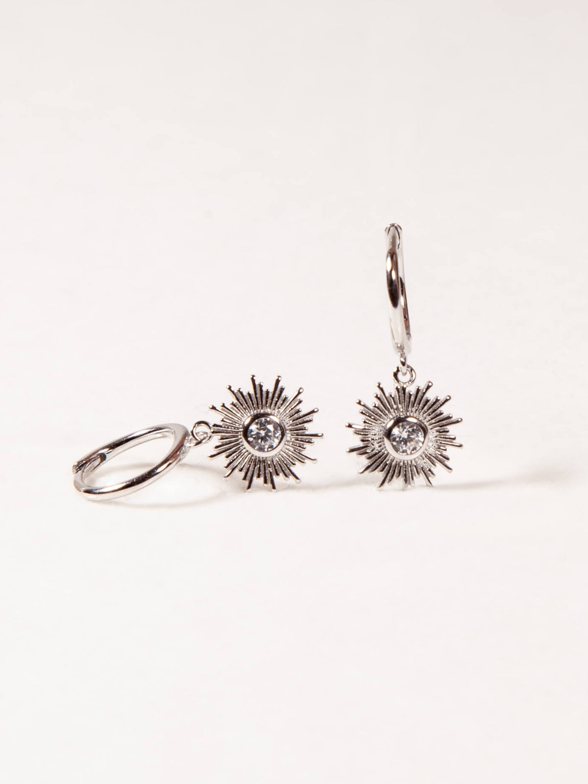 Sun-shaped earrings on a white background