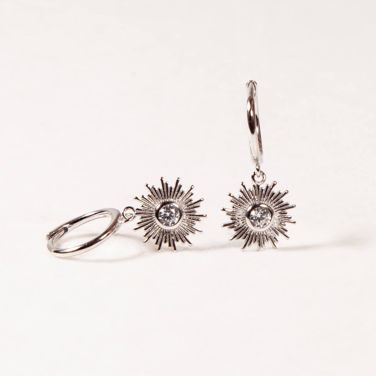 Sun-shaped earrings on a white background