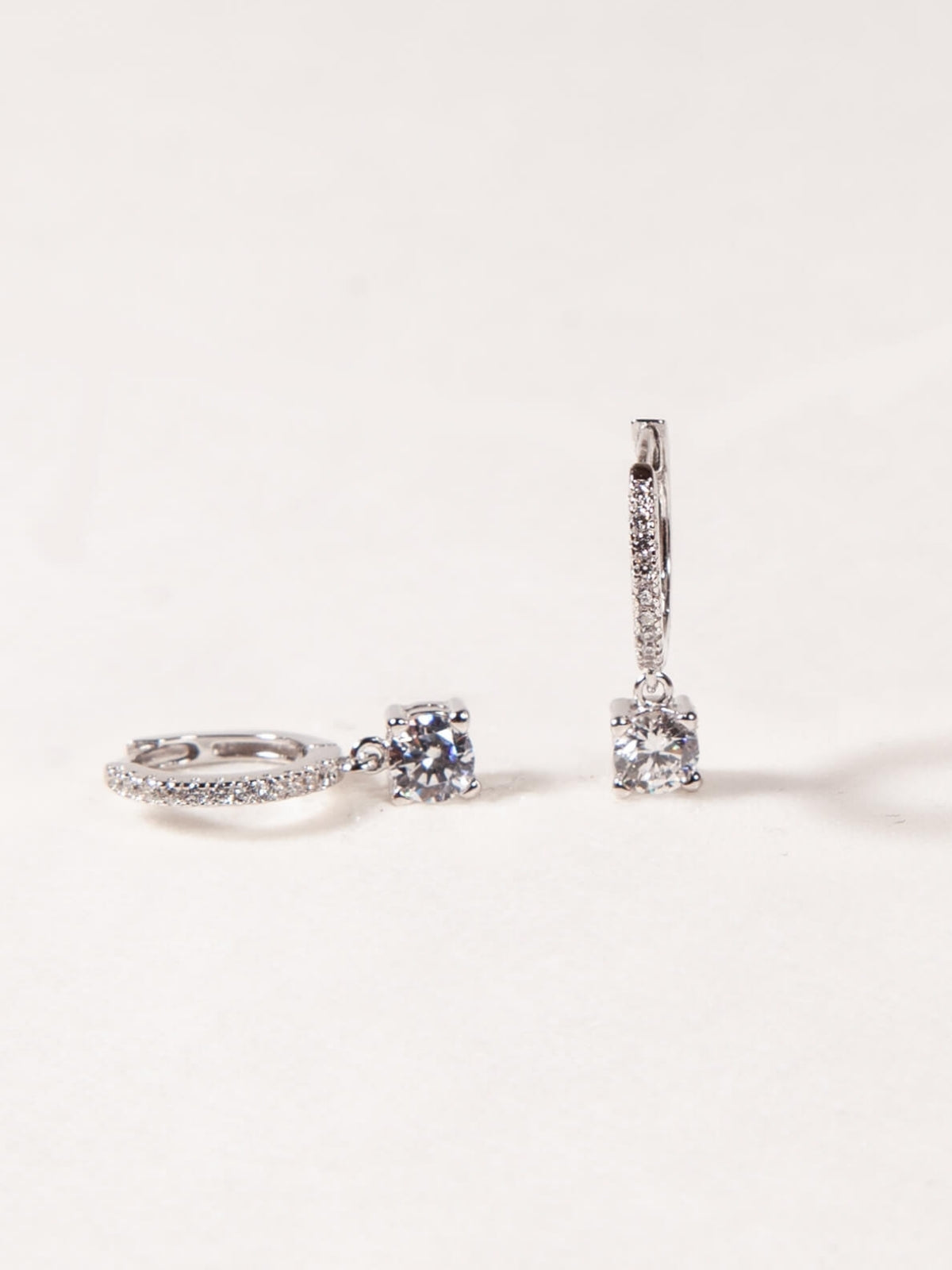 Diamond ring and earrings on a light gray background