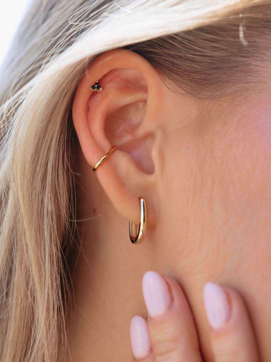 Close-up of an ear wearing gold hoop earrings