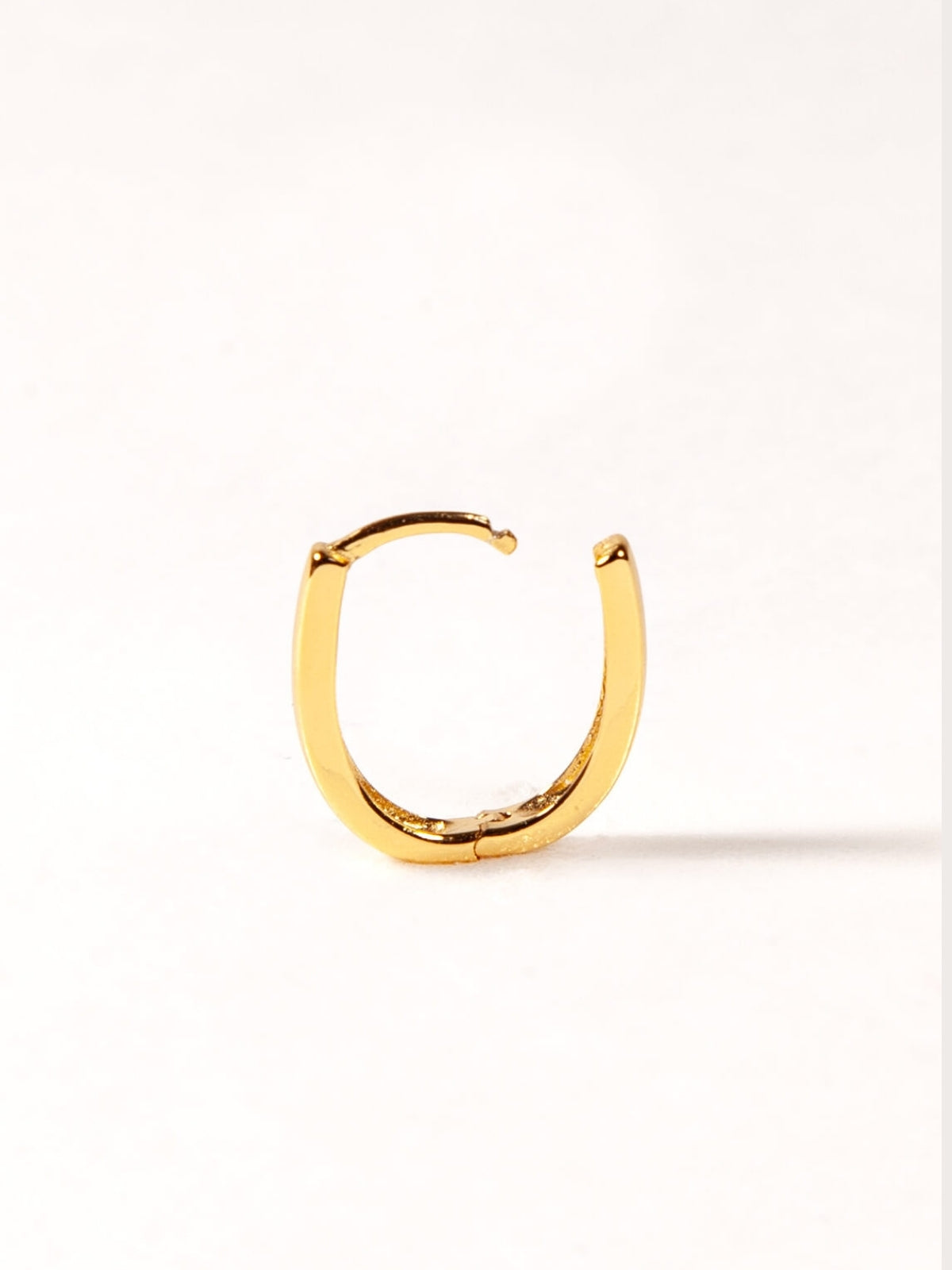 Gold hoop earring on a white background