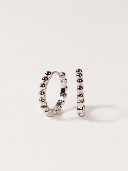 Pair of silver hoop earrings on a light gray background