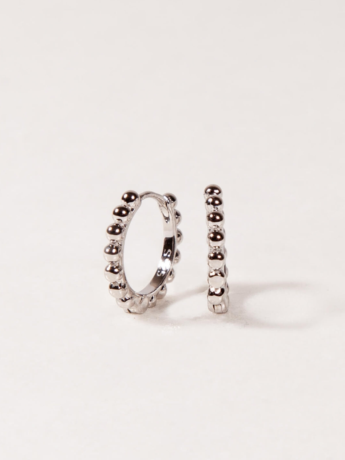 Pair of silver hoop earrings on a light gray background