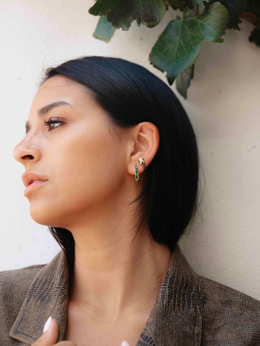 A woman profile view wearing an ear stack green color