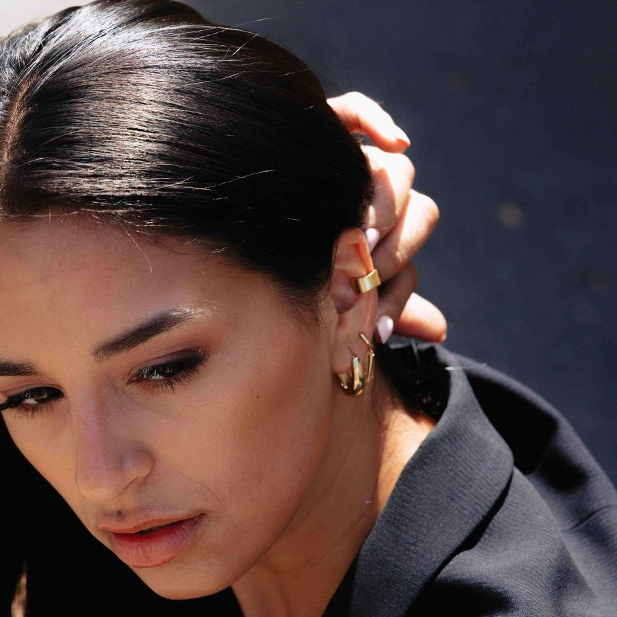 A close up photo of a woman wearing Wide Reversible Ear Cuff