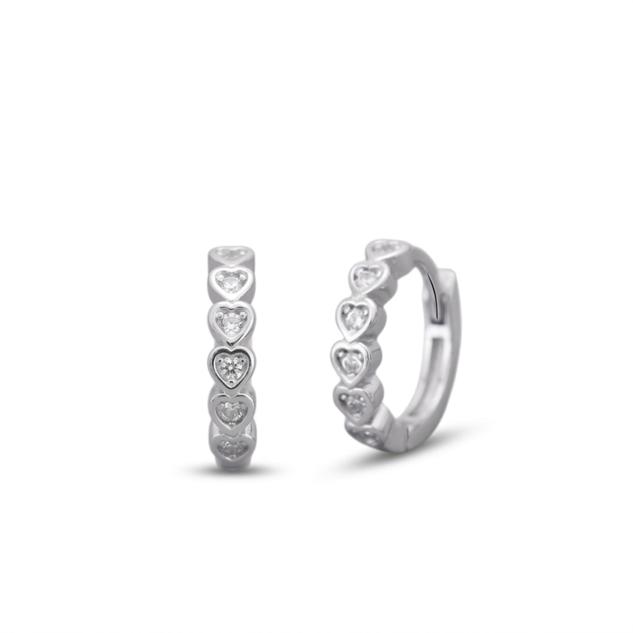 Pair of silver hoop earrings with heart-shaped cz on a white background