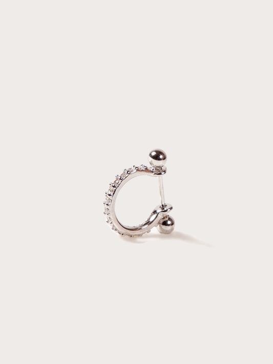 Silver hoop earring for helix or conch with embedded stones on a light beige background