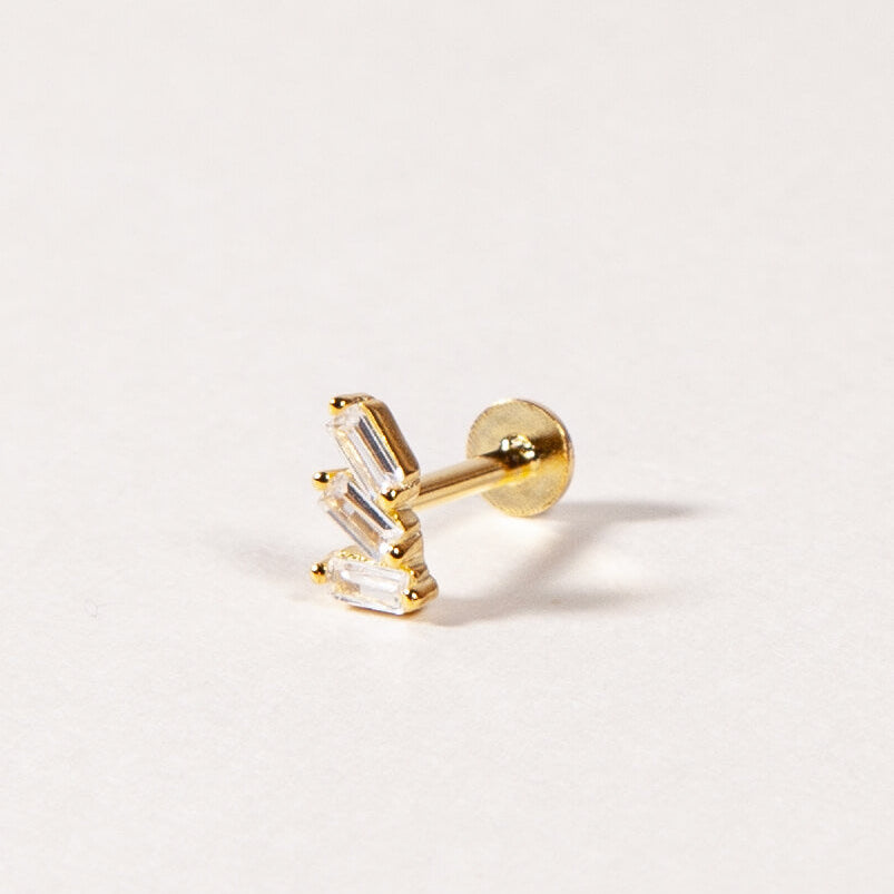 A single gold-colored flatback stud earring with cubic zirconia stones.