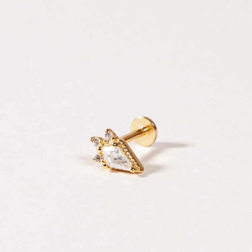kite shape gold flatback stud on a light beige background