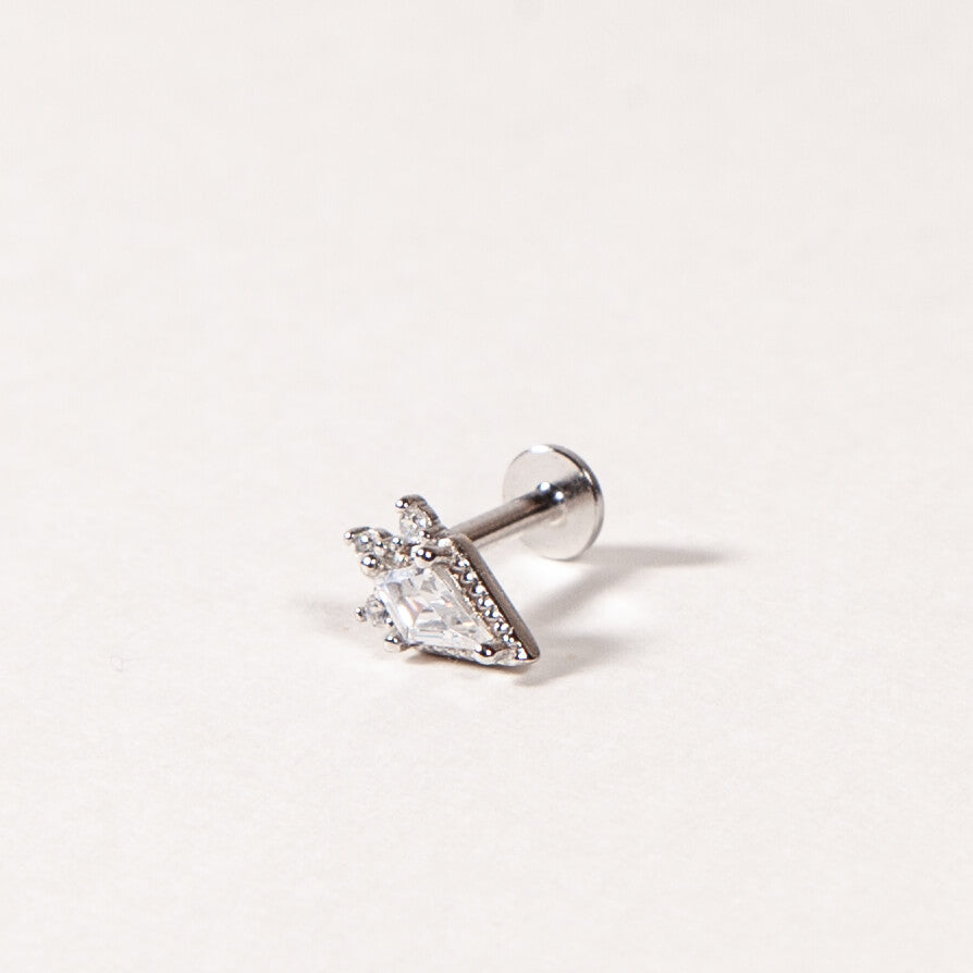 Single stud earring with clear gemstone on a light gray background