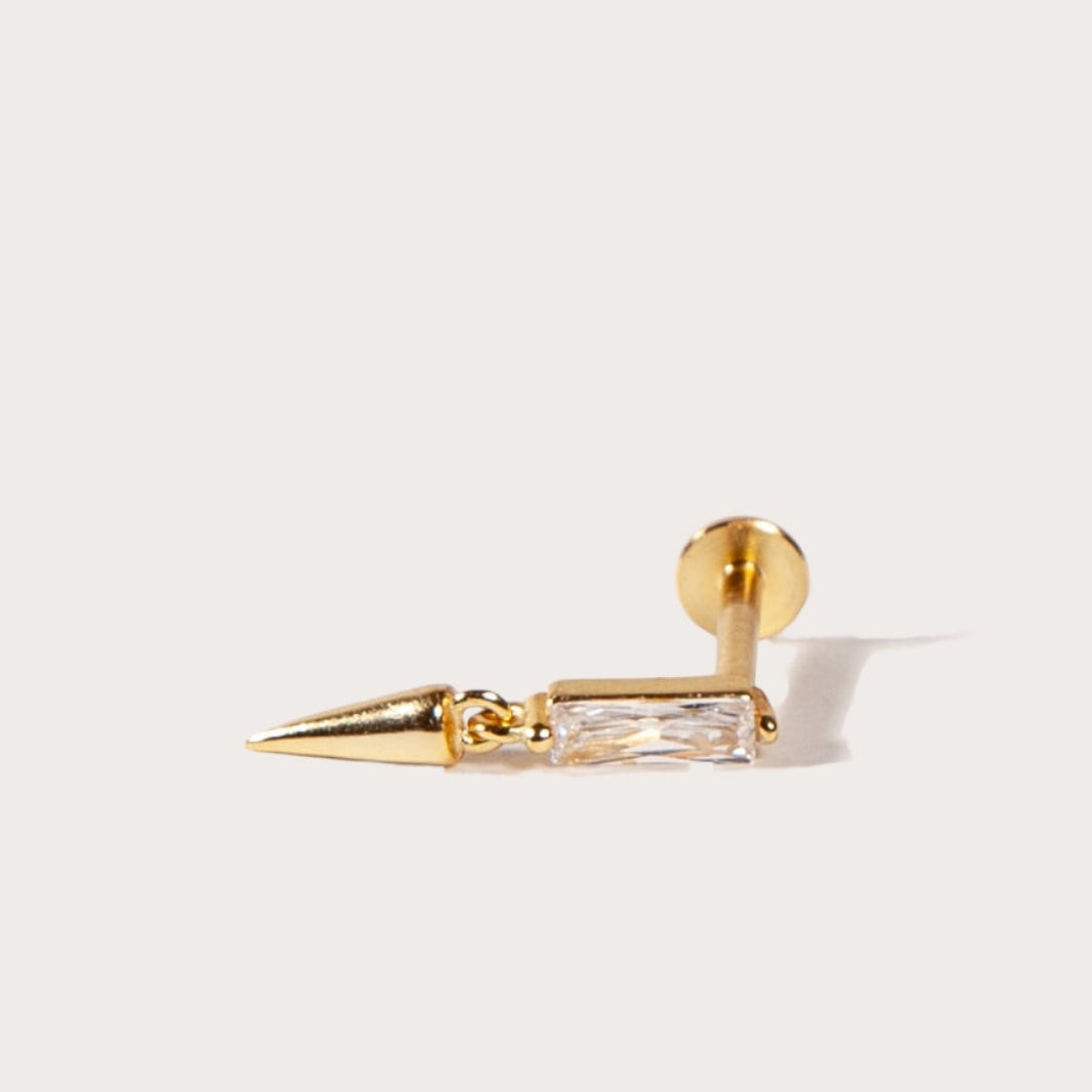 Gold spike earring on a light gray background