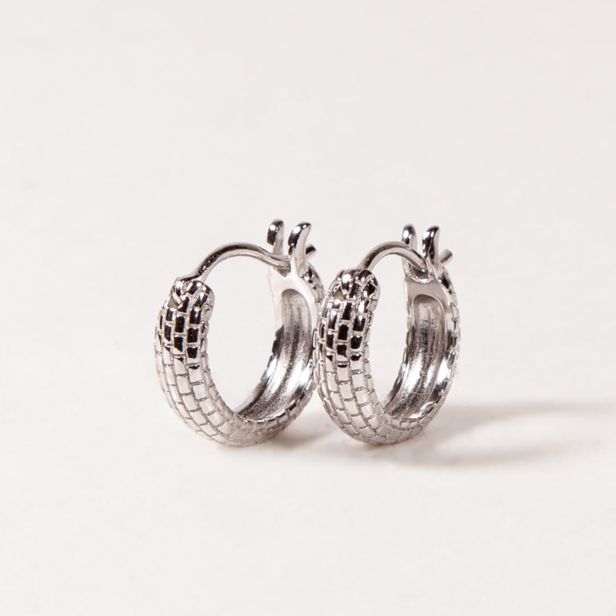 Pair of silver hoop earrings on a light gray background