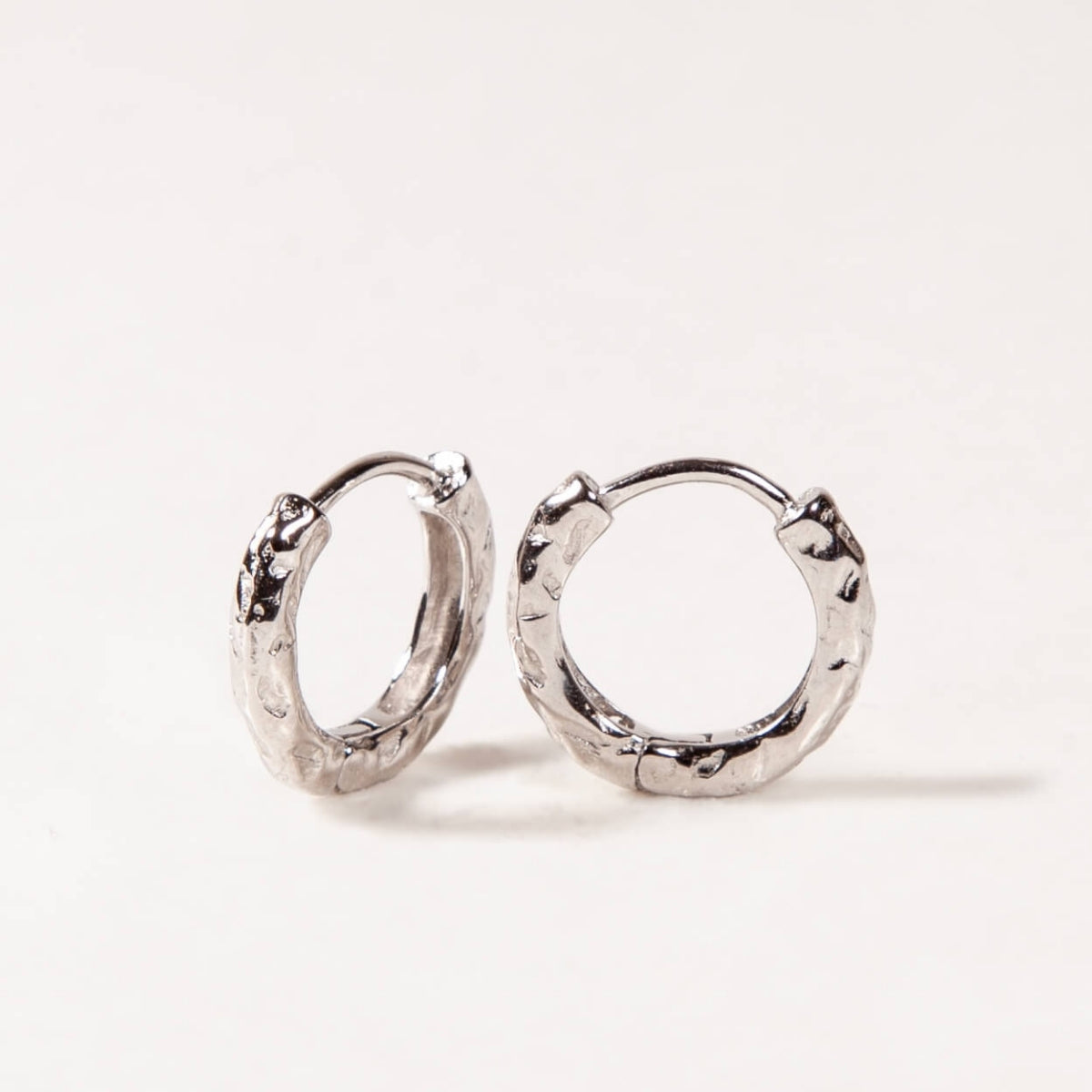 Silver hoop earrings on a light gray background