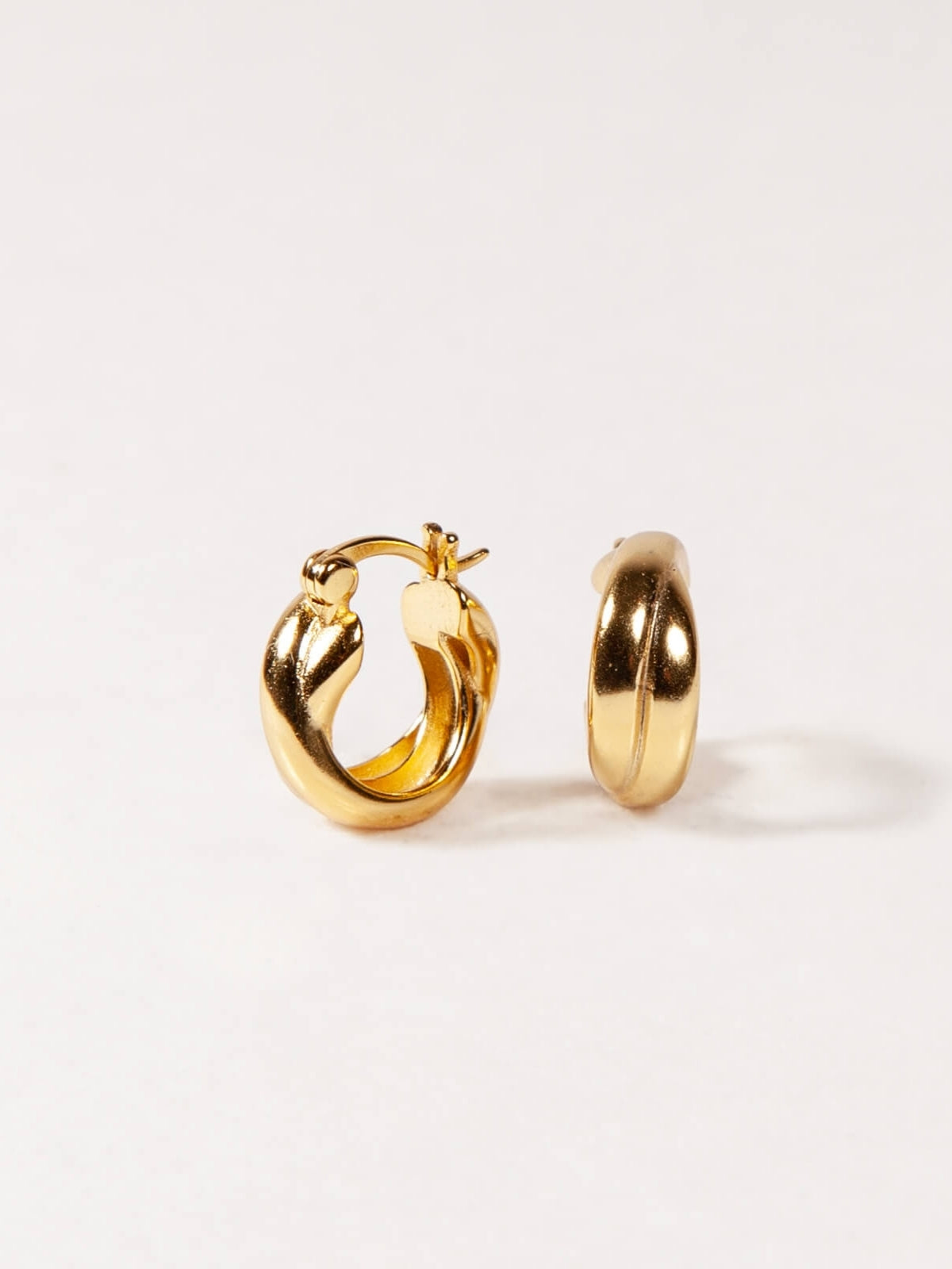 Gold Twisted hoop earrings on a white background