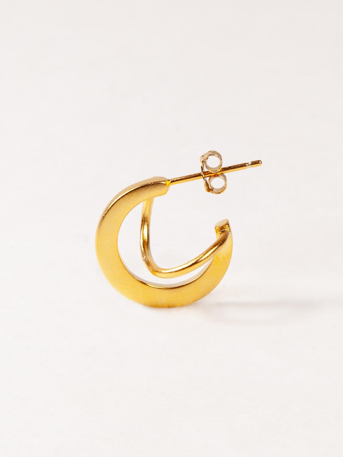 Gold hoop earring on a white background