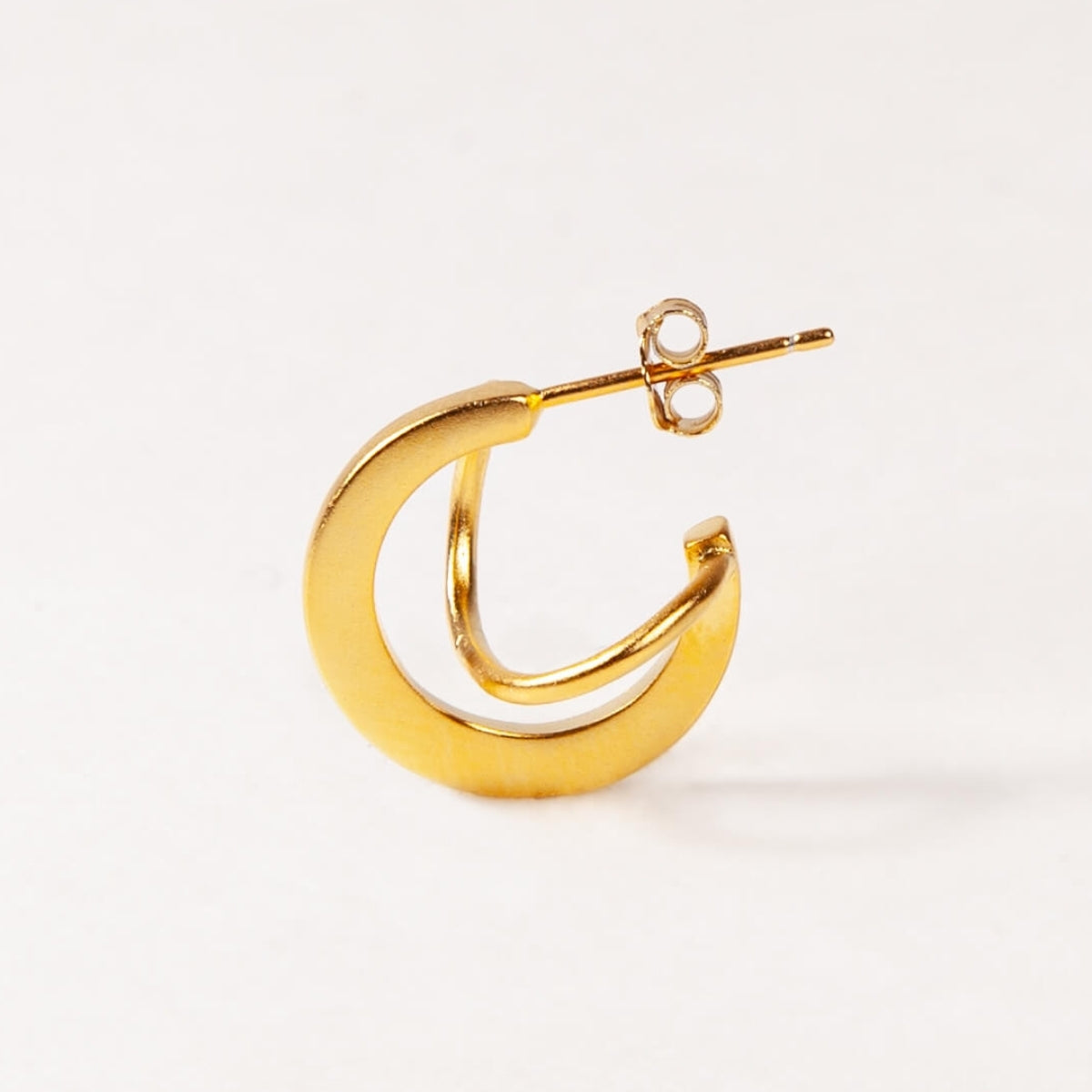 Gold hoop earring on a white background