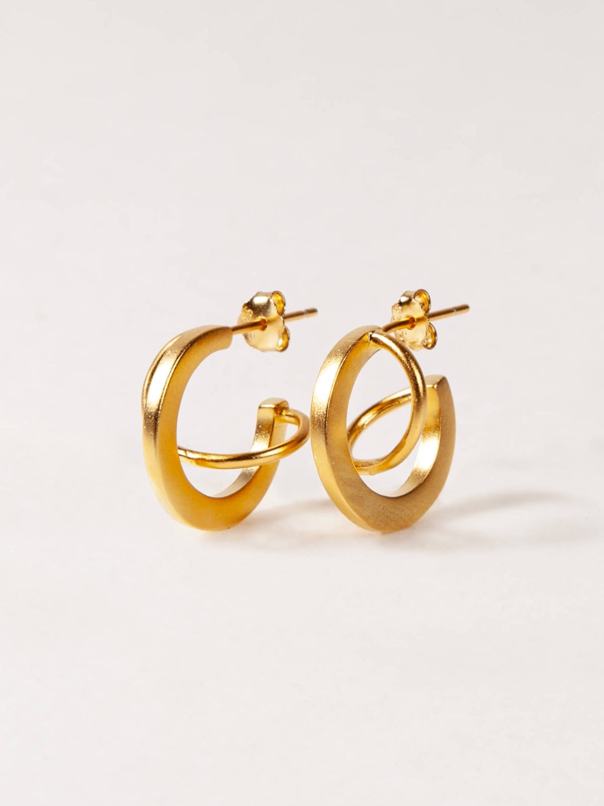 Pair of gold hoop earrings on a light gray background