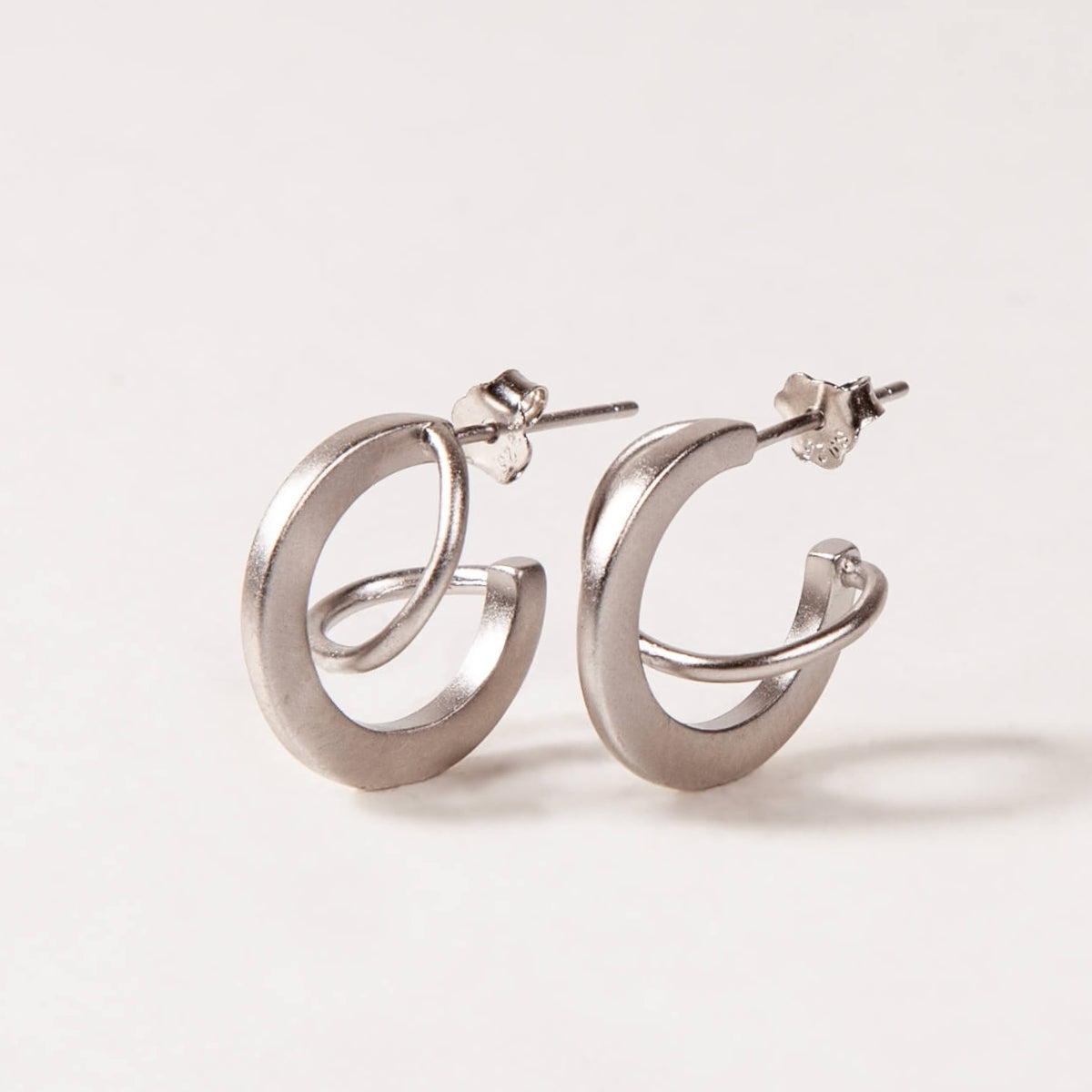 Silver hoop earrings on a light gray background