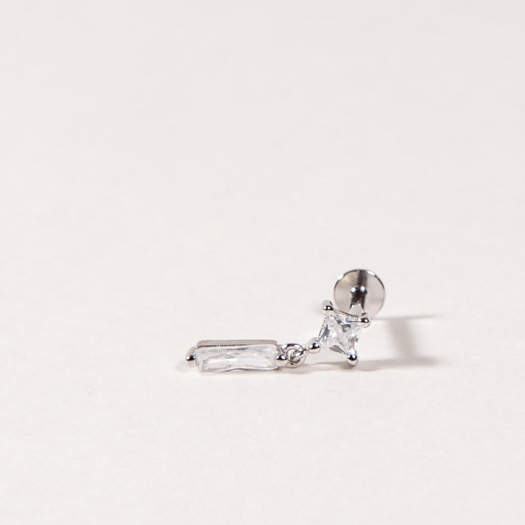 Silver earring with a clear cz on a light gray background