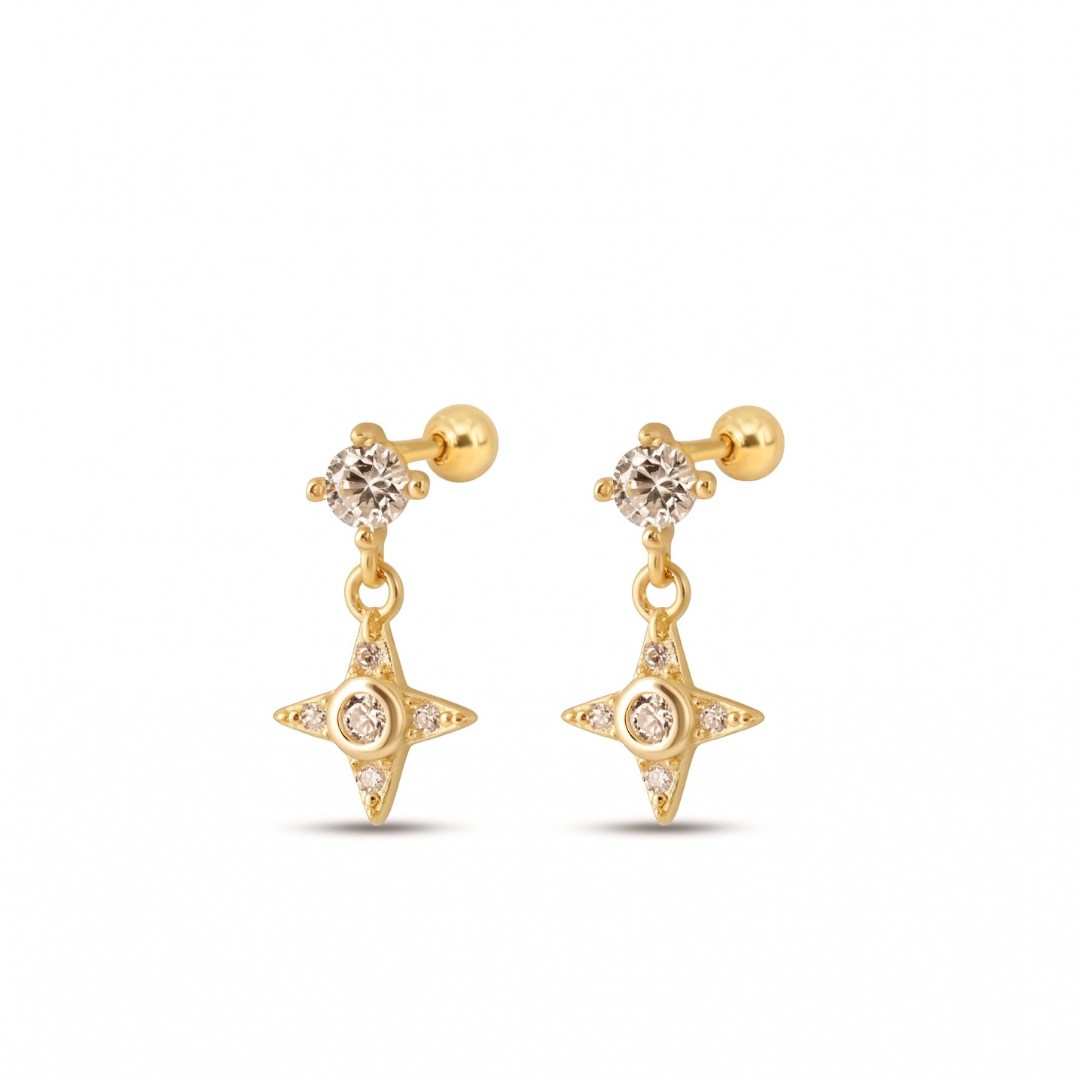 A pair of gold dangle stud earrings featuring a small round clear gemstone on the post and a four-pointed star charm with a central clear cz, shown on a plain white background.
