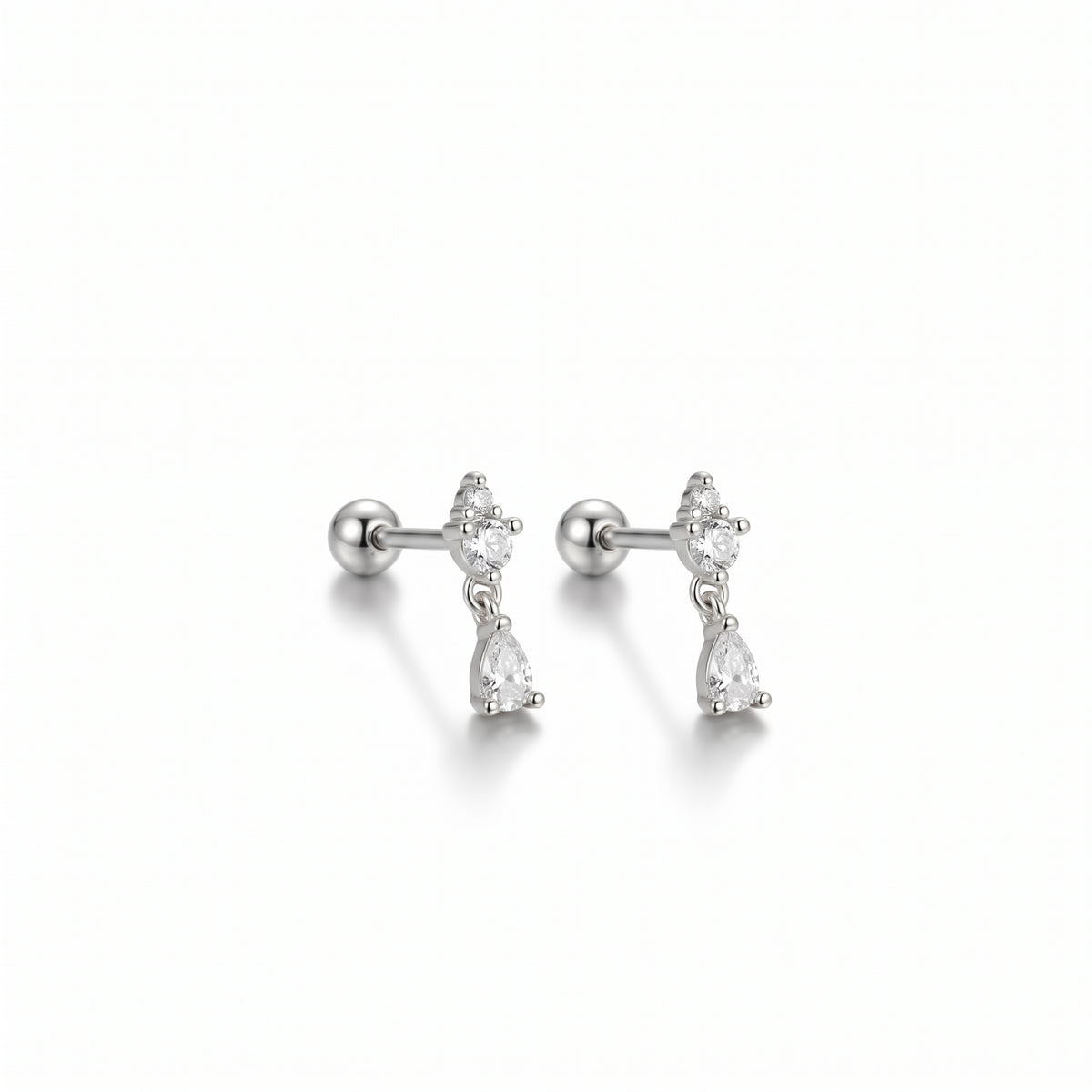 A pair of silver-toned labret stud earrings with a small cluster of clear pear-cut stones above a larger teardrop-shaped clear stone, shown on a clean white background.