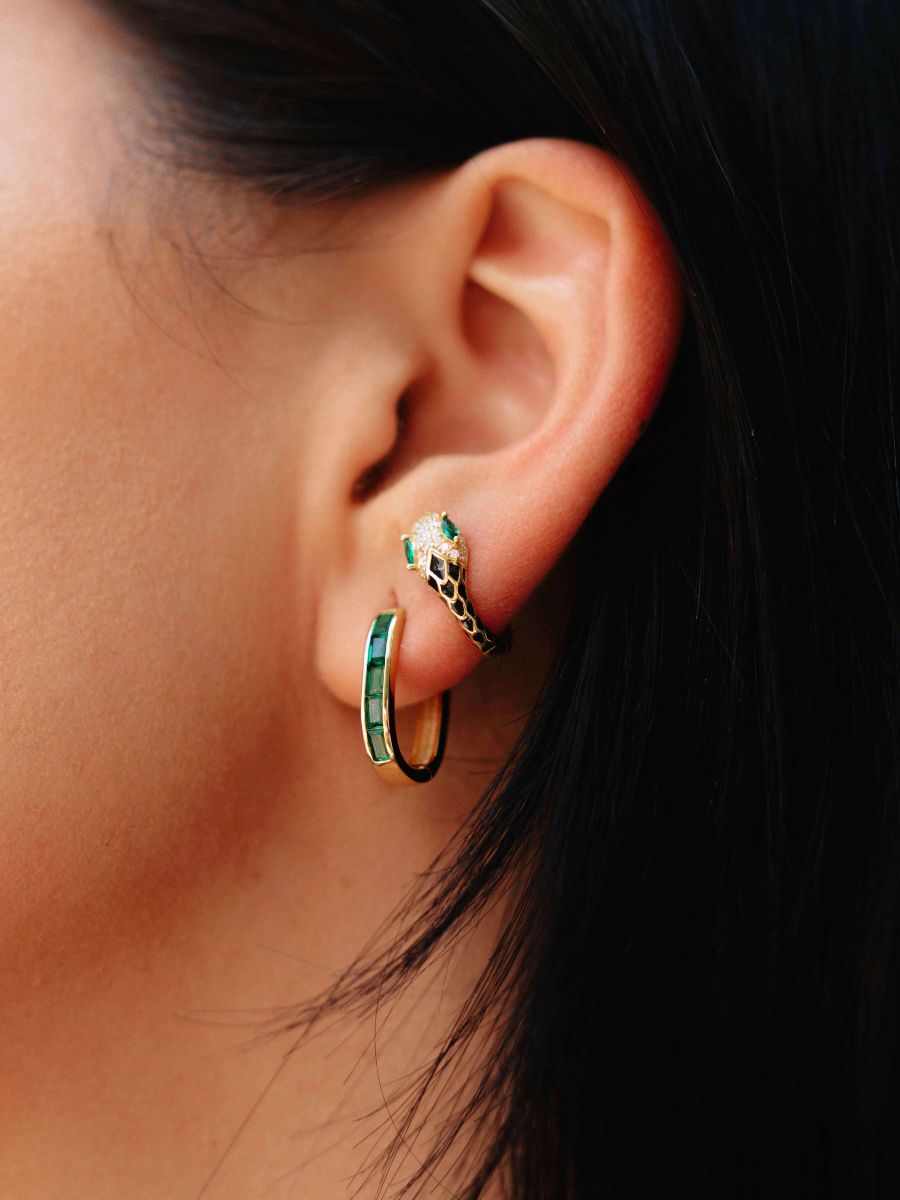 Close up of a ear wearing snake hoop earrings