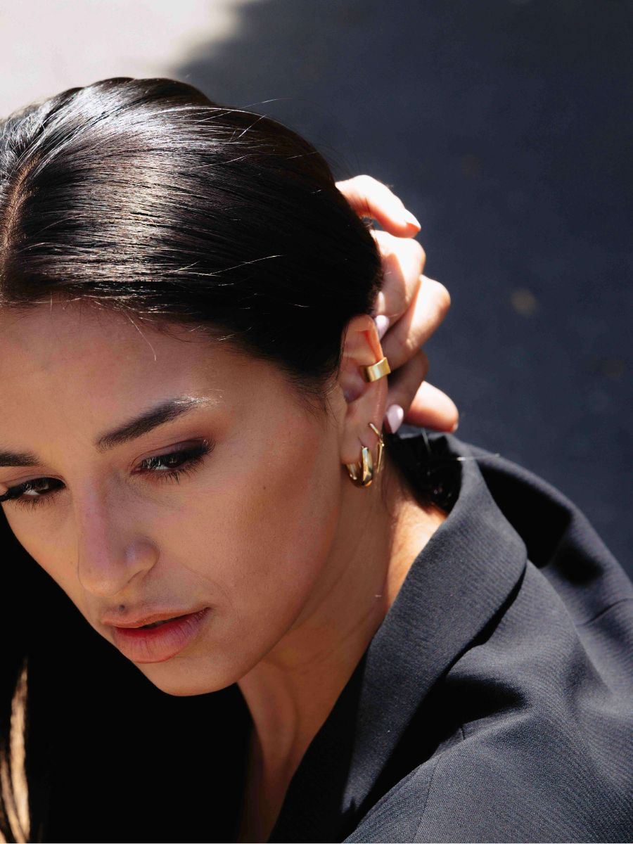  A close up photo of a woman wearing Wide Reversible Ear Cuff 