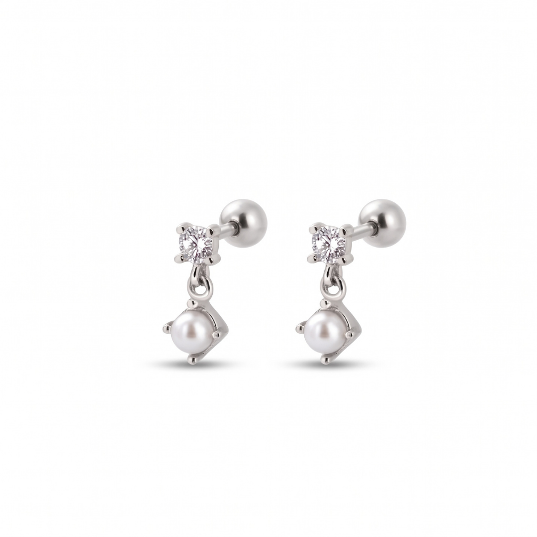 A pair of silver-toned stud earrings featuring a small clear gemstone and a dangling white pearl, shown on a plain white background.
