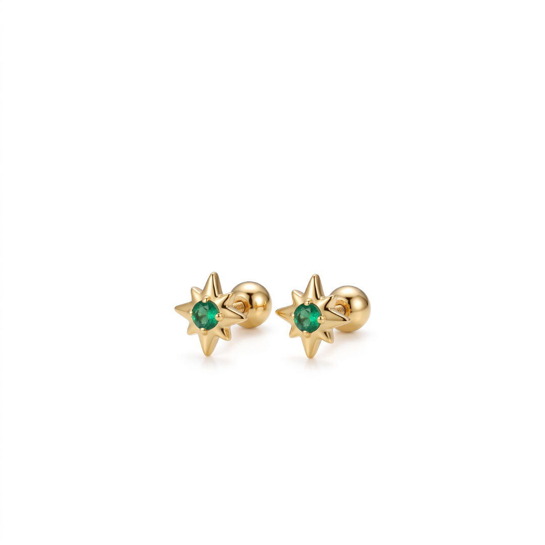 A pair of gold starburst stud earrings with a small round green gemstone in the center, set against a plain white background.
