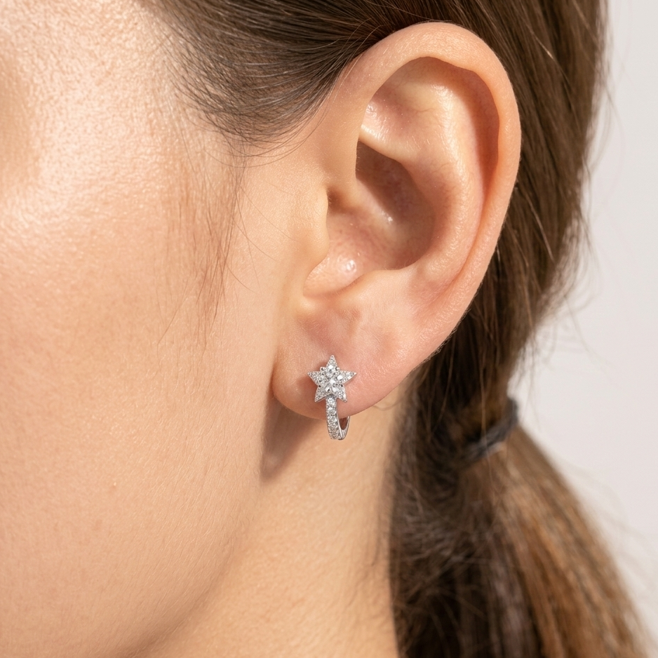 Close-up of an ear wearing a star-shaped earring with a blurred background