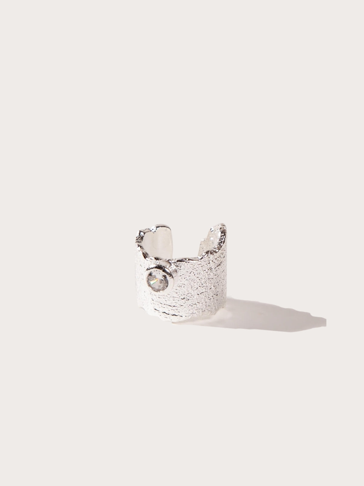 Silver Textured cuff with a central bezel CZ on a light gray background