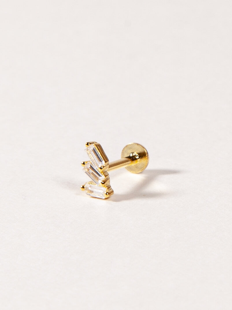 A single gold-colored flatback stud earring with cubic zirconia stones.