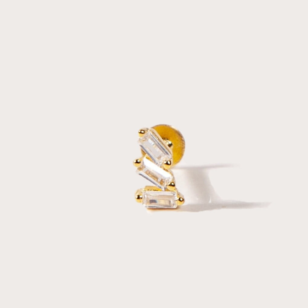 Gold and clear CZ earring on a white background