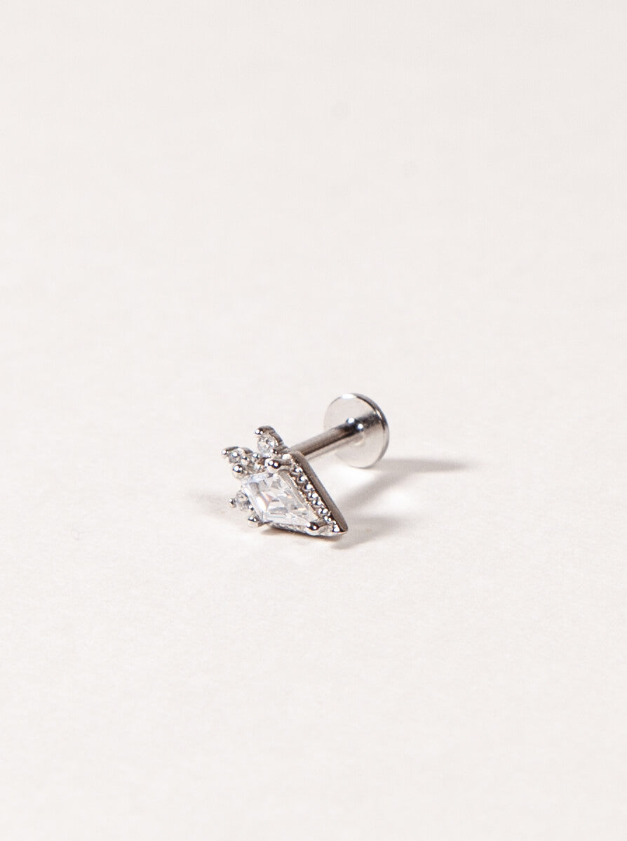 Single stud earring with clear gemstone on a light gray background
