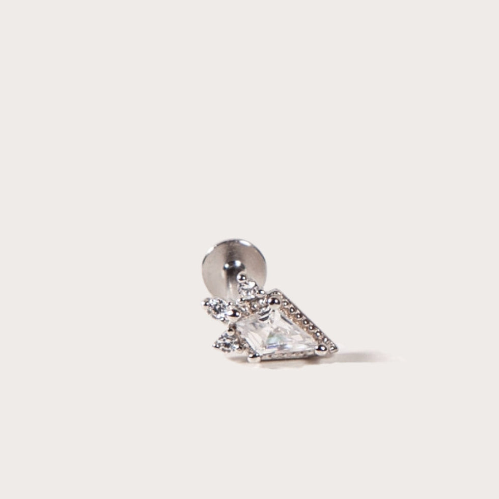Silver earring with a clear gemstone on a light gray background