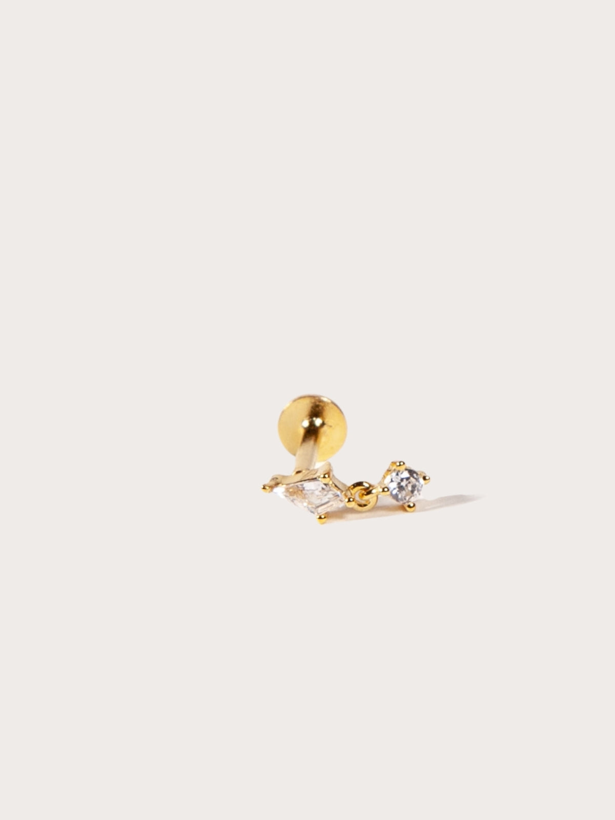 Gold earring with a small round CZ on a white background