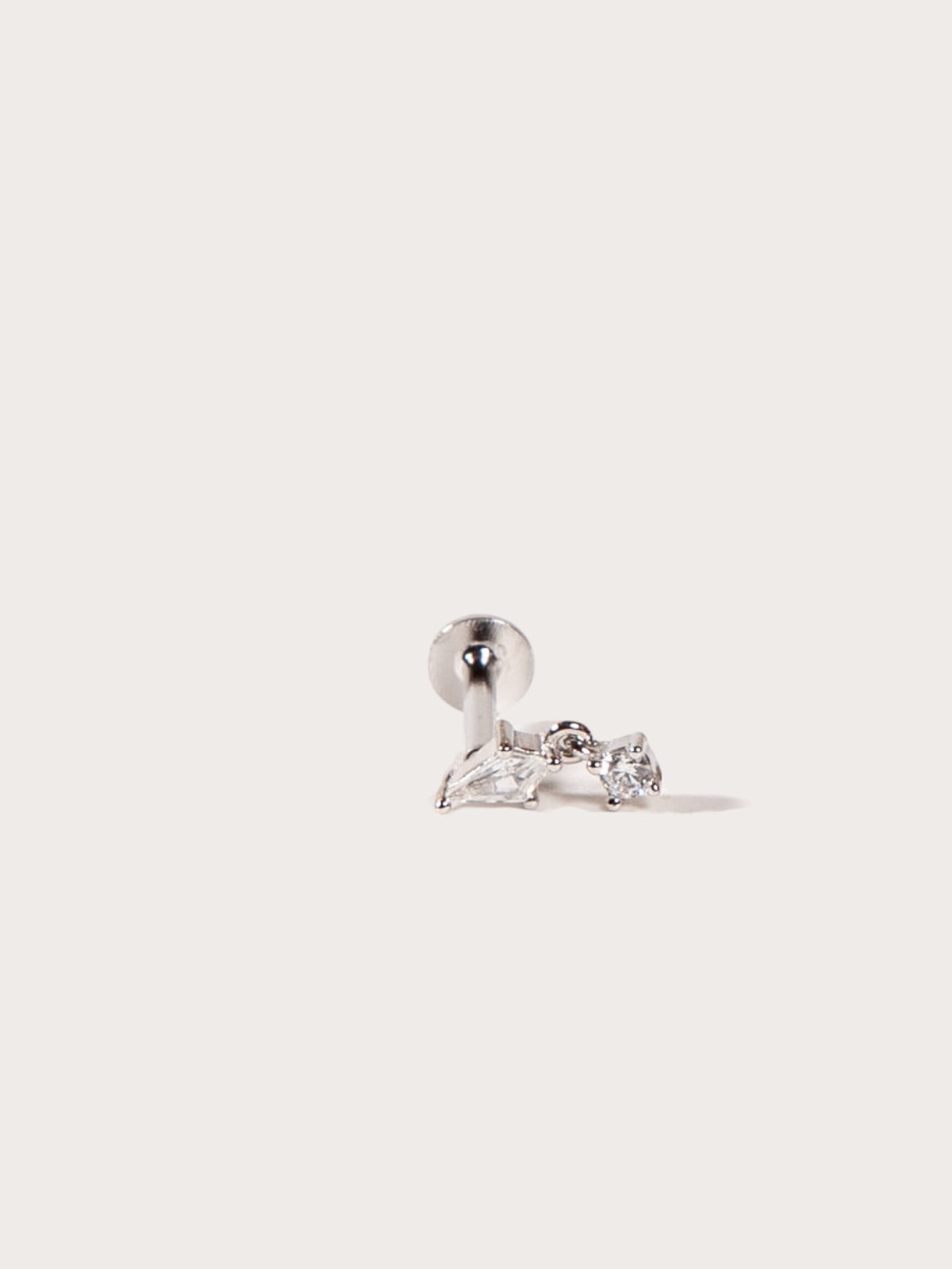 Silver earring with clear CZ on a light gray background