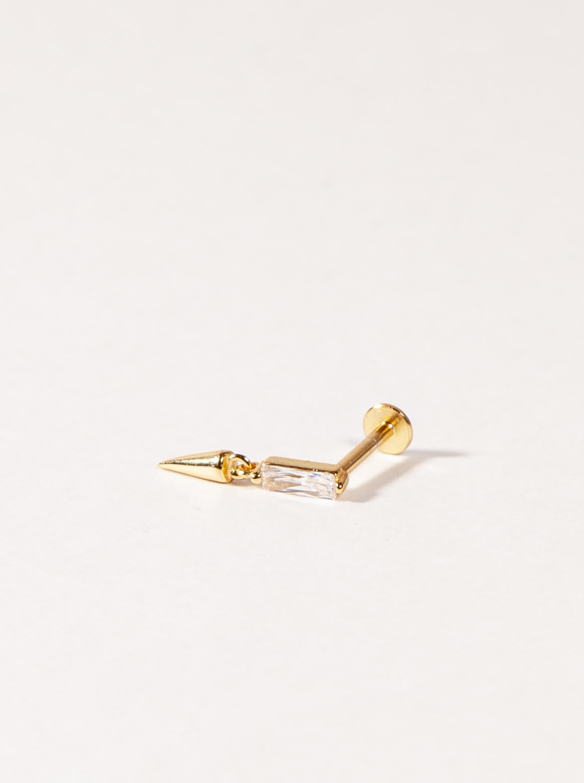 A single flatback stud earring with a gold-colored post and clear cubic zirconia stone against a white background.