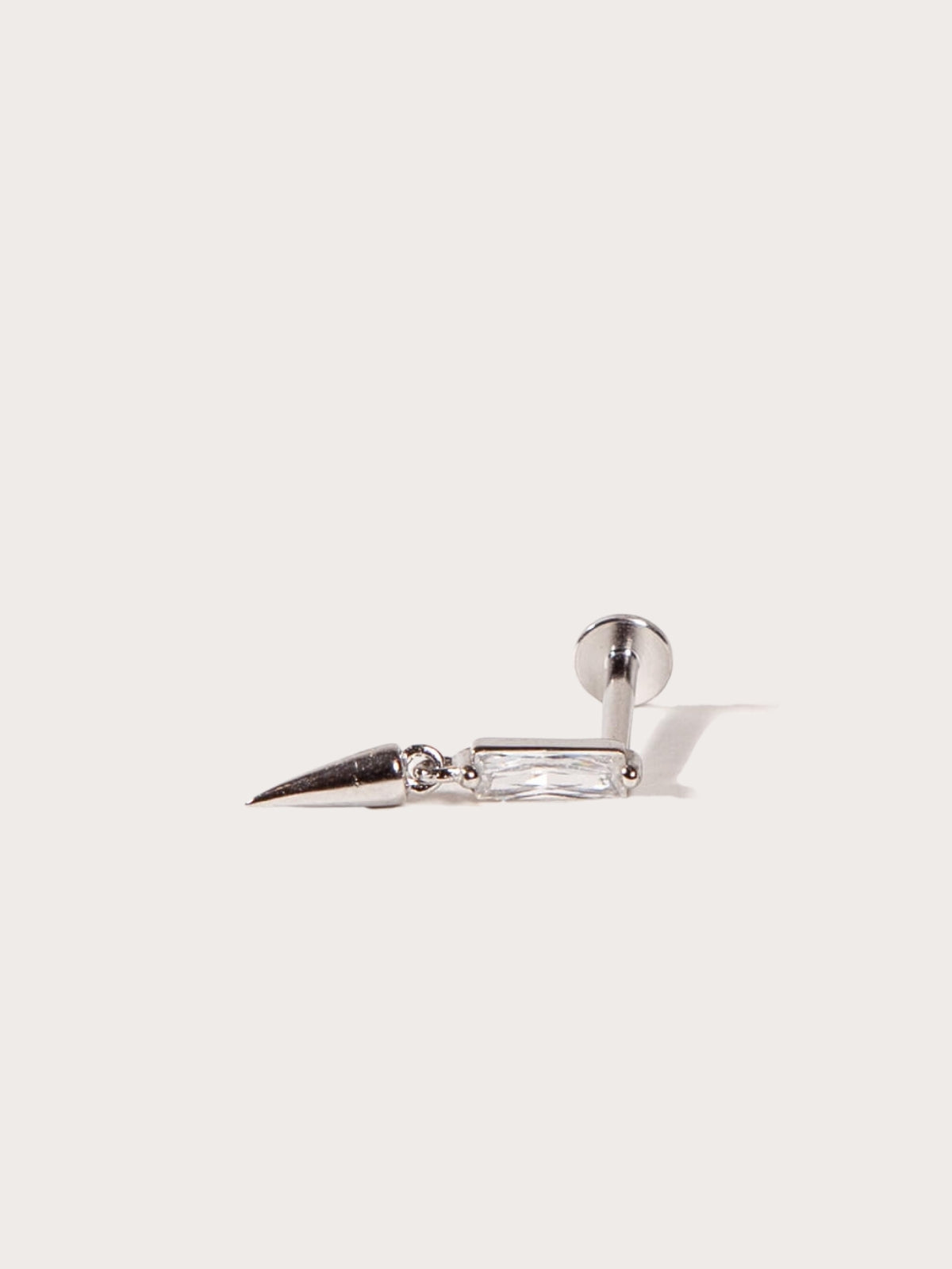 Silver spike earring on a light gray background