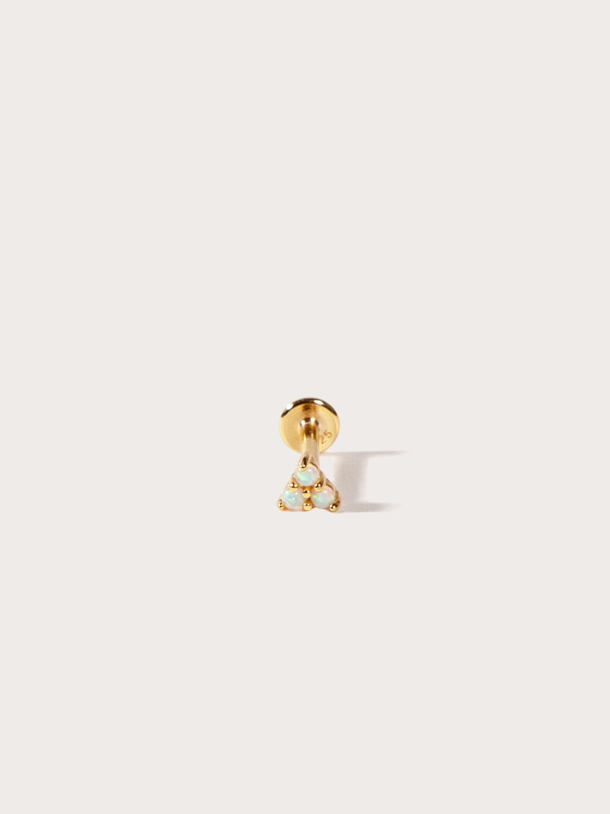 Gold earring with a small triangle stones on a white background