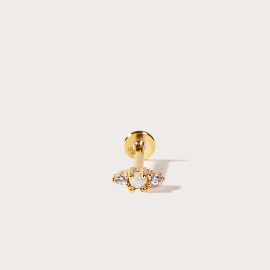 Gold flatback earring with a clear gemstone on a white background