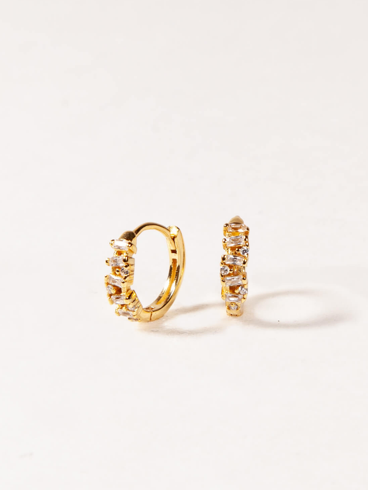 Gold hoop earrings with embedded stones on a white background