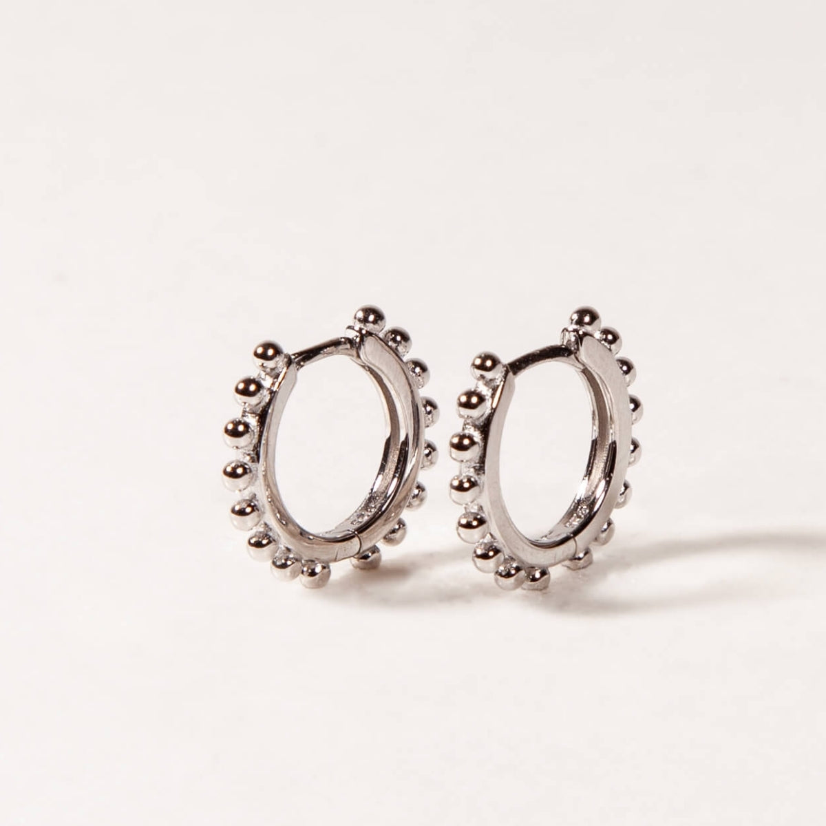 Pair of silver hoop earrings on a light gray background
