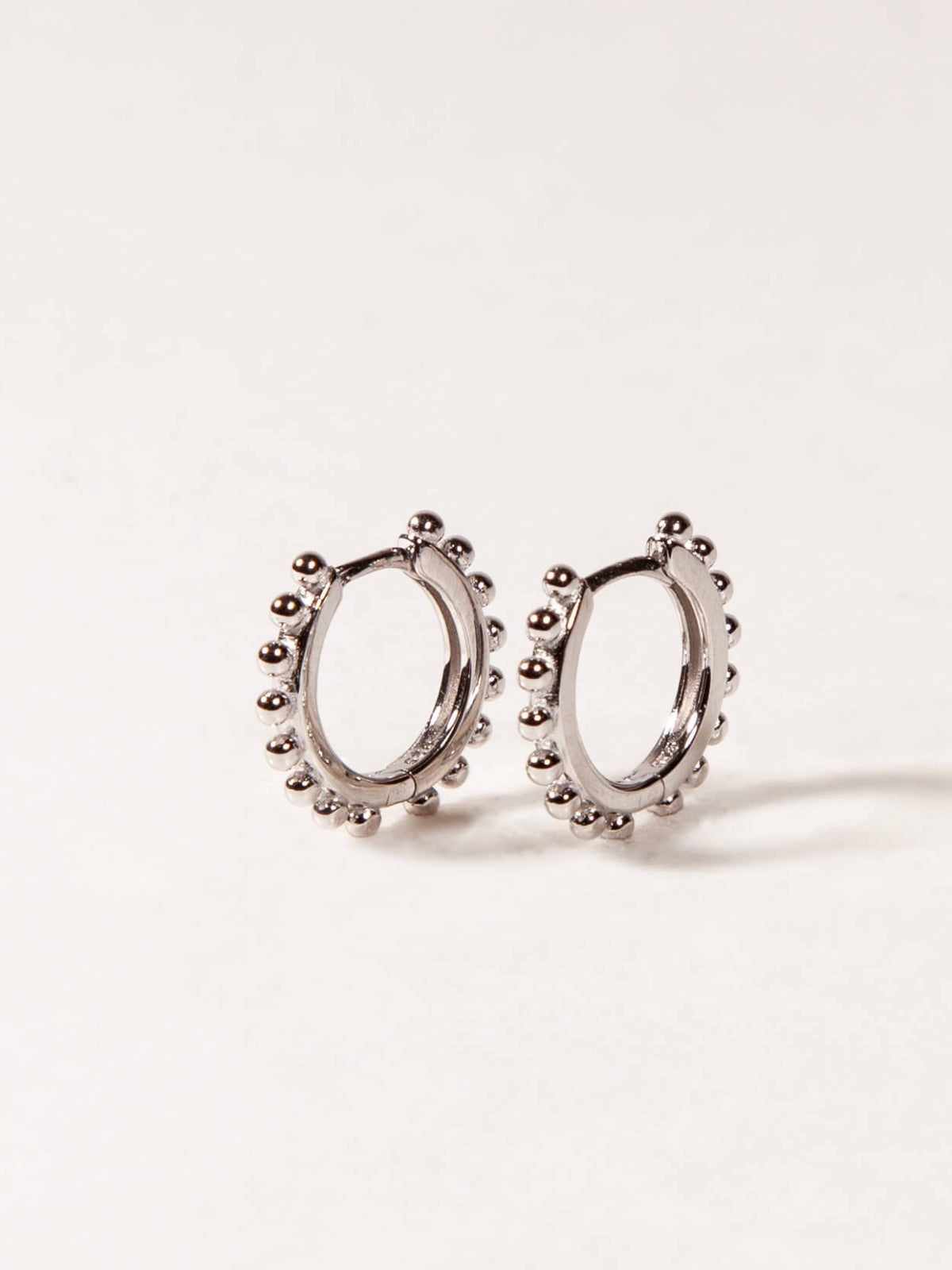 Pair of silver hoop earrings on a light gray background