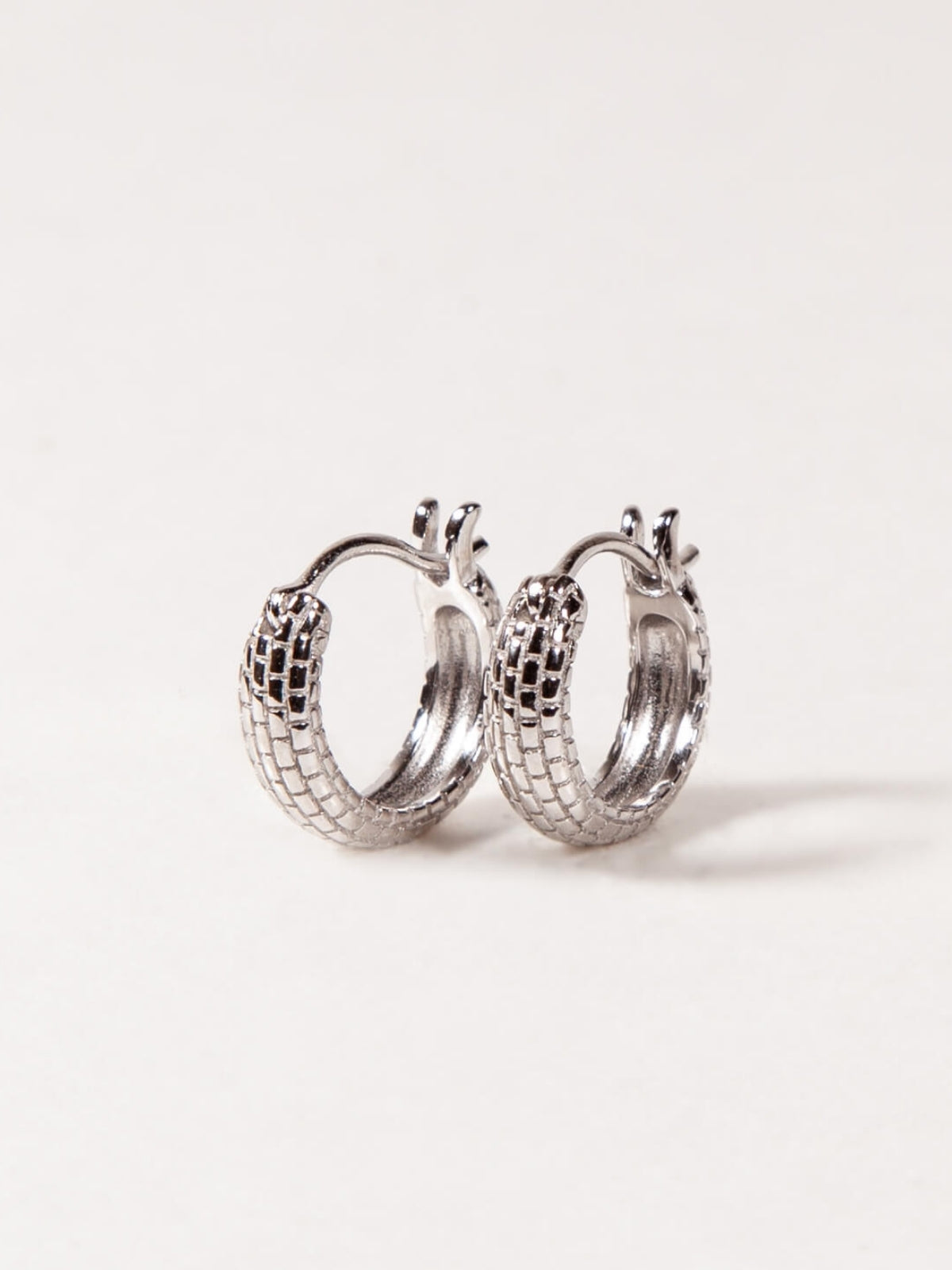 Pair of silver hoop earrings on a light gray background