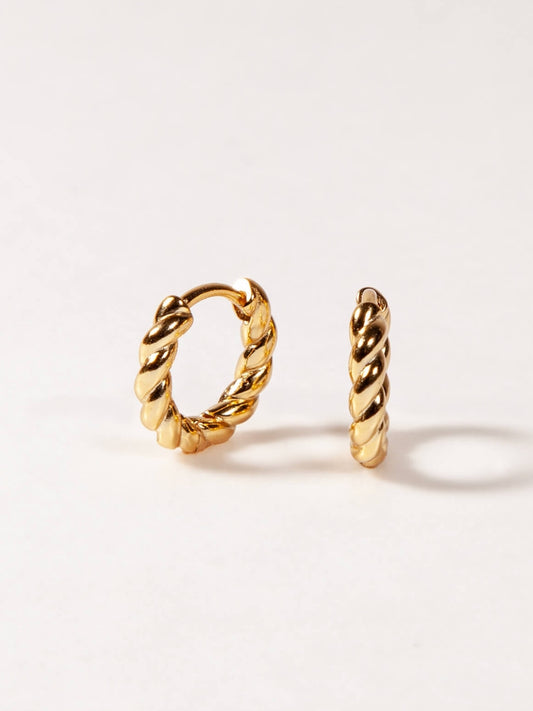 Pair of gold twisted hoop earrings on a white background