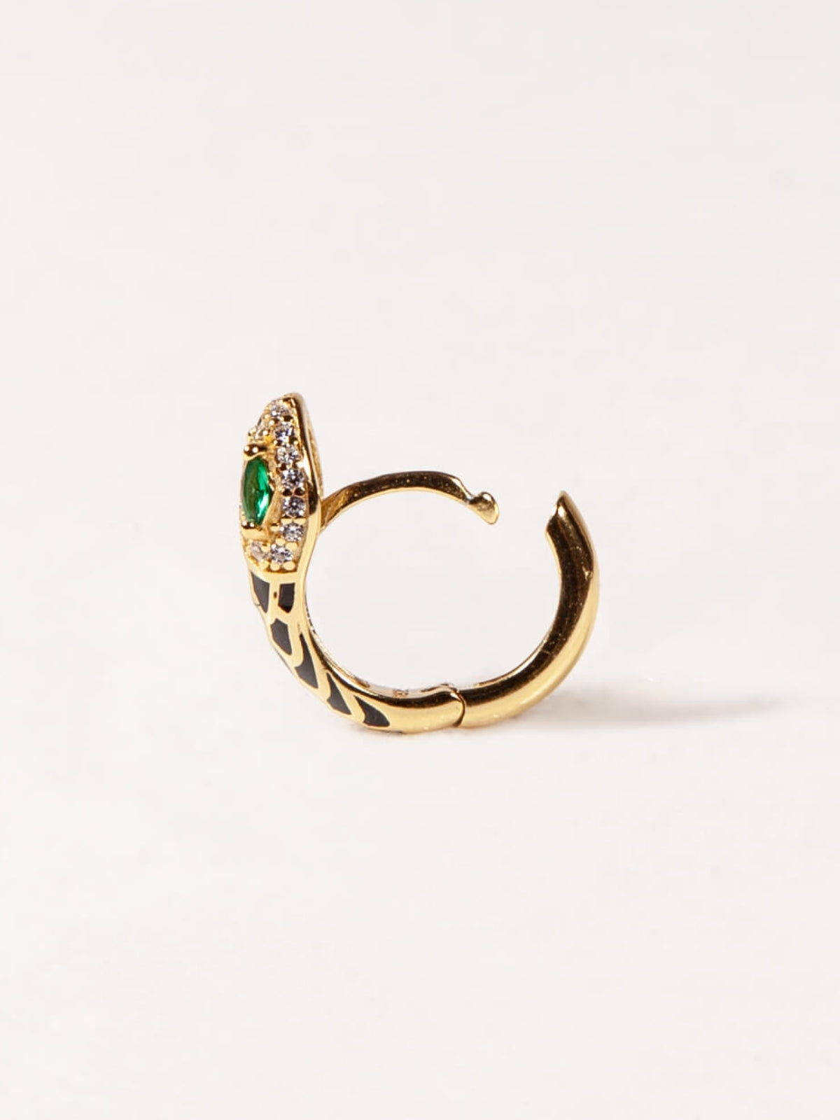 Gold hoop earring with green gemstone on a white background