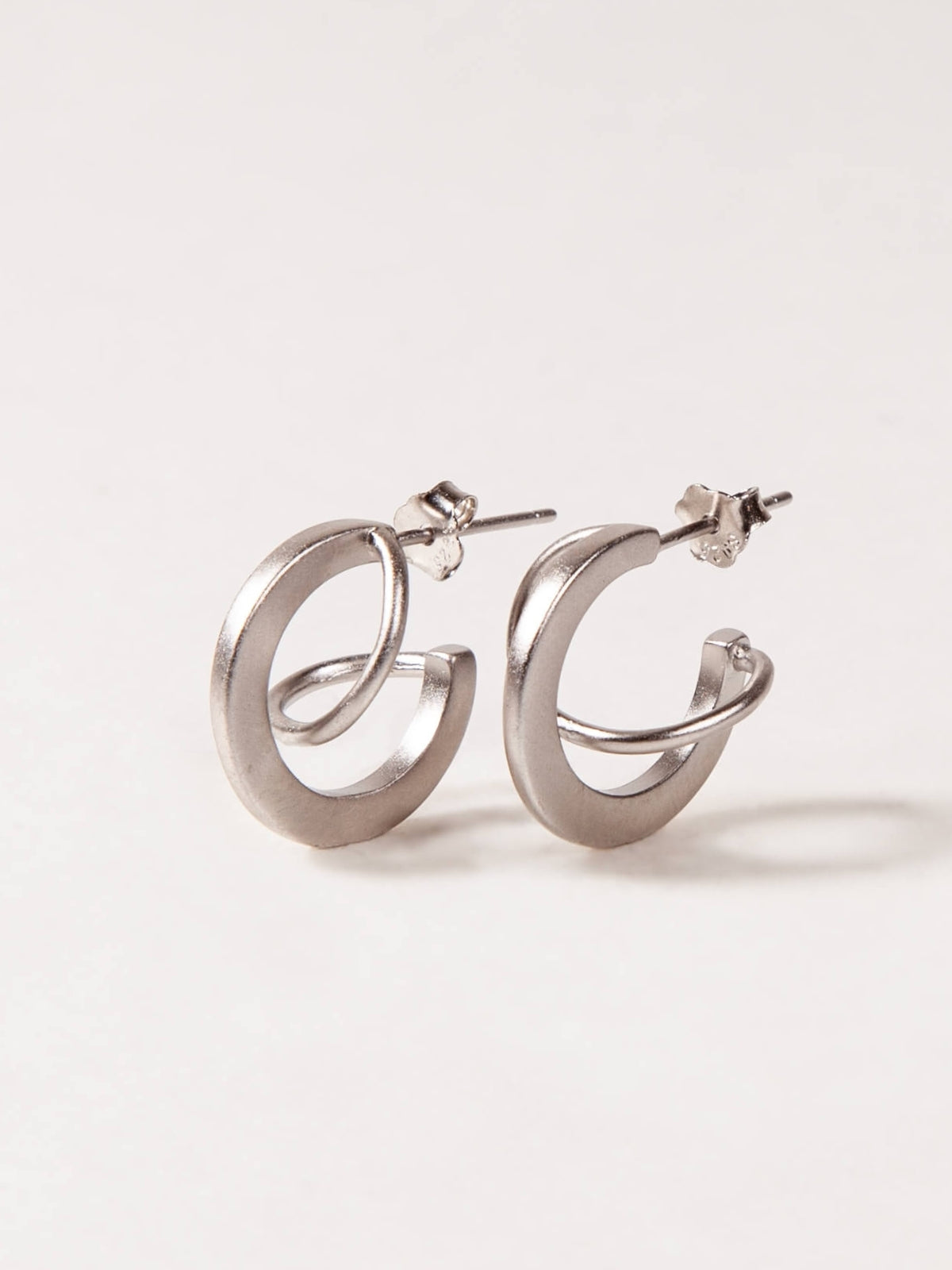 Silver hoop earrings on a light gray background