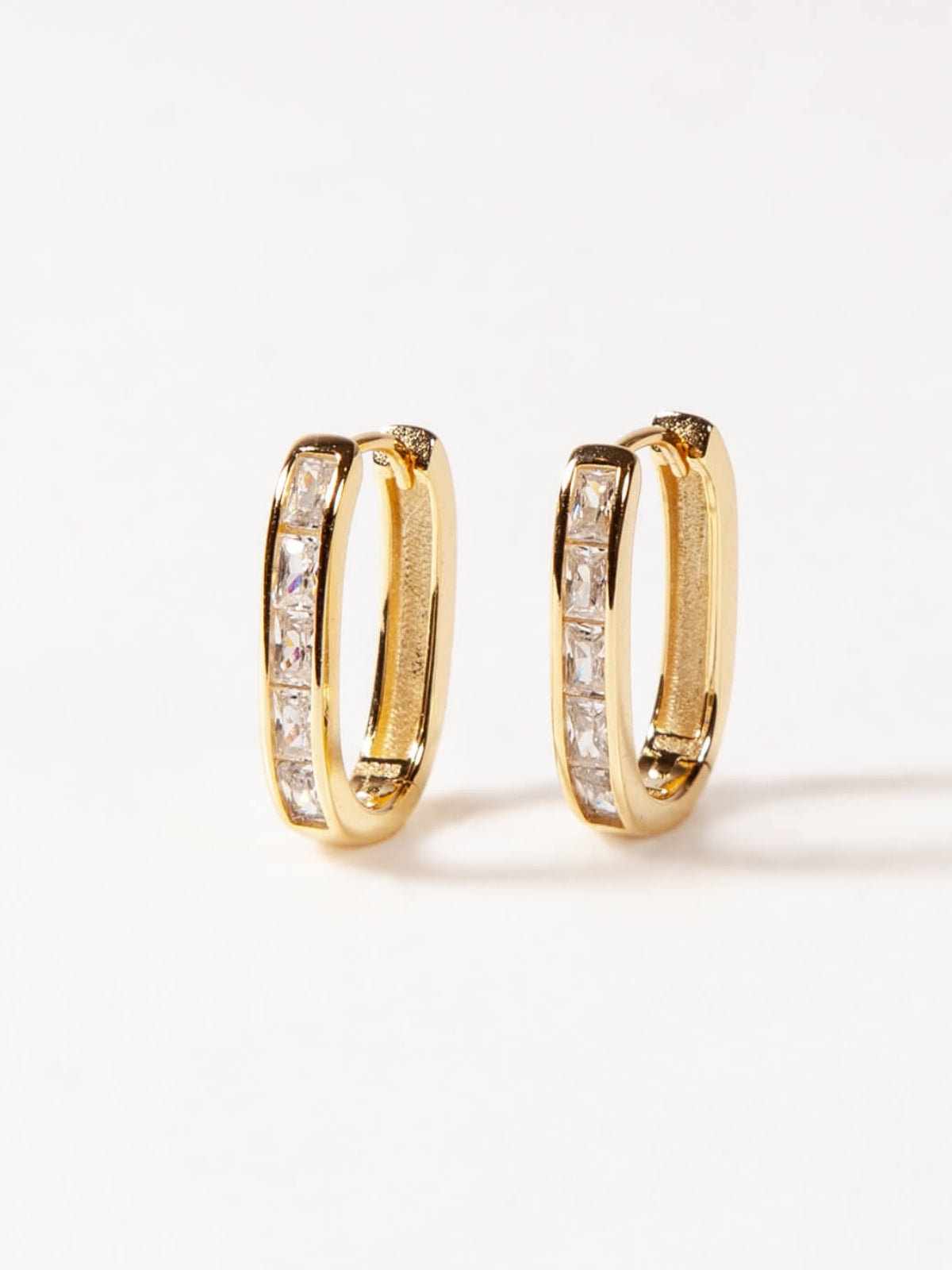 Gold U Shaped hoop earrings with embedded stones on a white background