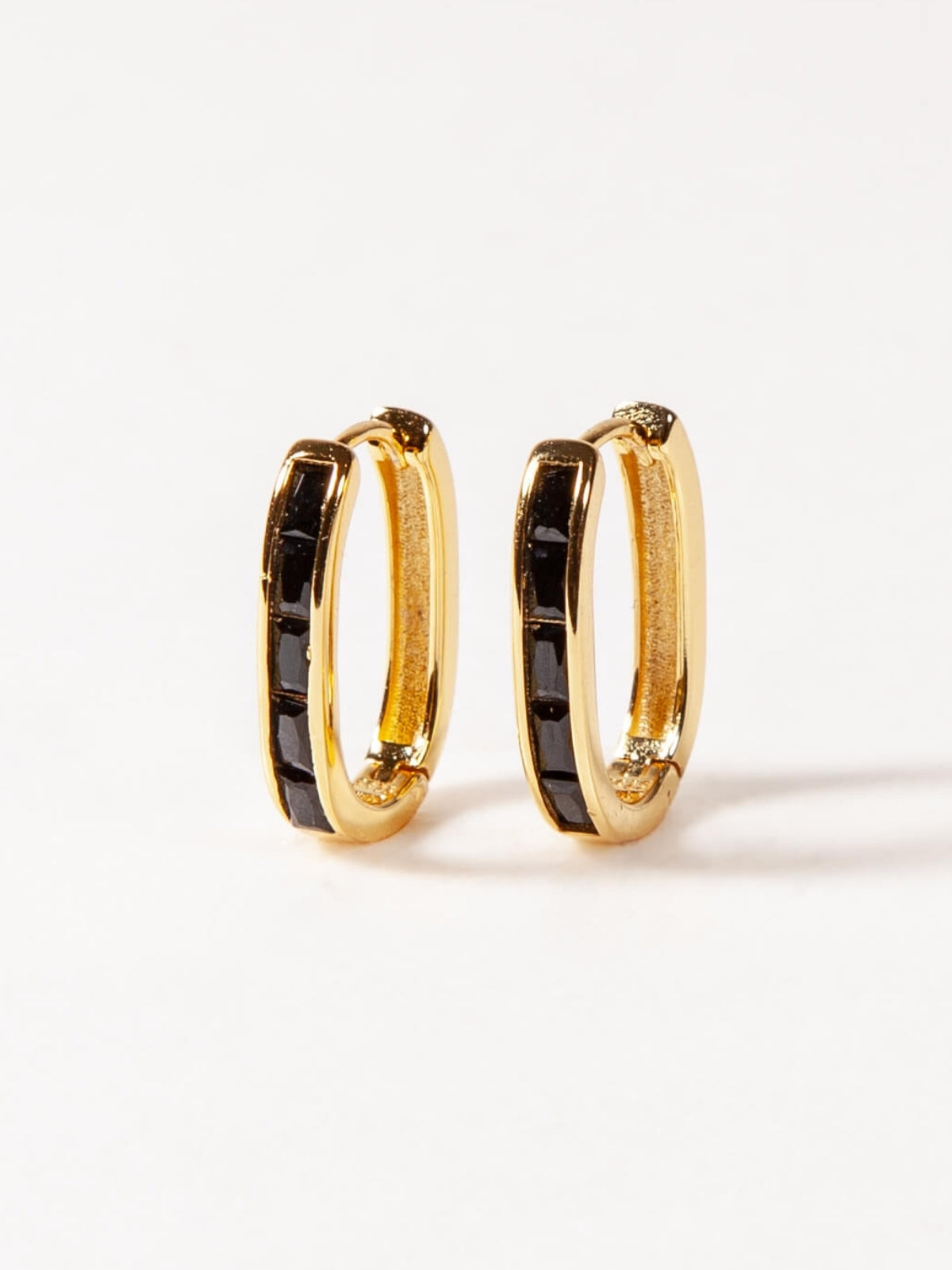 Gold U hoop earrings with black accents on a white background